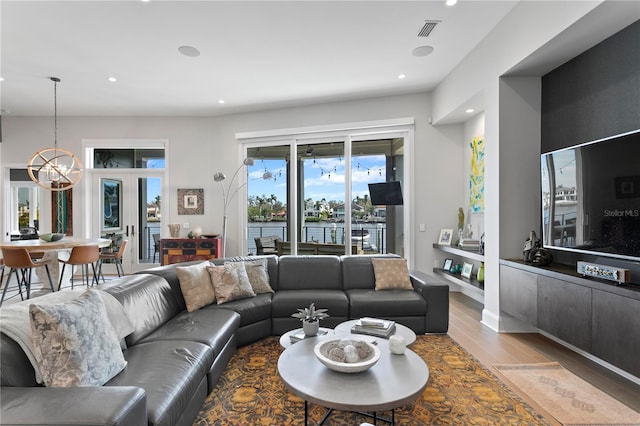 living room featuring a notable chandelier and light wood-type flooring