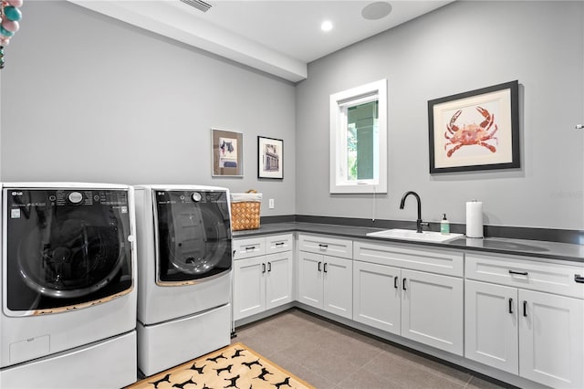 laundry area featuring washing machine and clothes dryer, sink, light tile patterned flooring, and cabinets