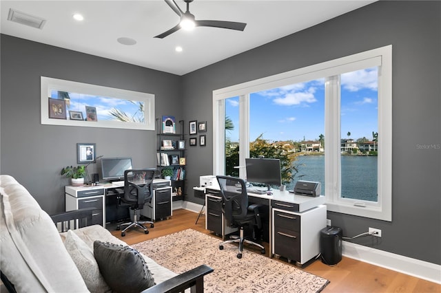 office with light hardwood / wood-style flooring and ceiling fan