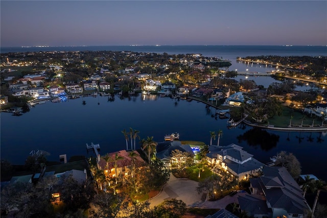 aerial view at dusk featuring a water view