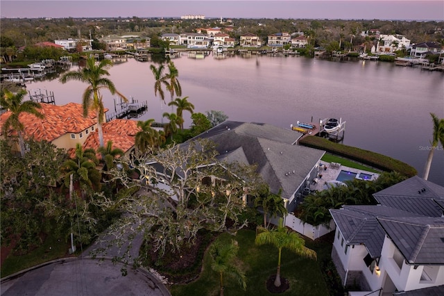 aerial view at dusk featuring a water view