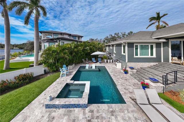 view of pool with an in ground hot tub, a yard, and a patio