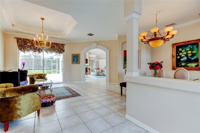 living room with a raised ceiling, decorative columns, crown molding, a chandelier, and light tile patterned floors