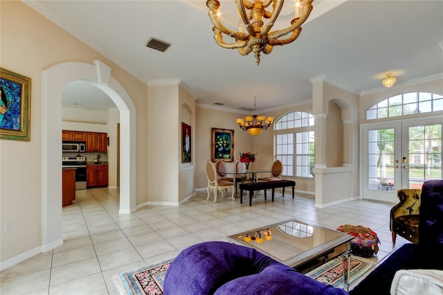 living room with a notable chandelier, light tile patterned floors, crown molding, and french doors