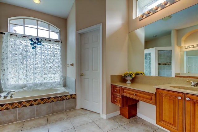 bathroom with tiled bath, tile patterned flooring, and vanity