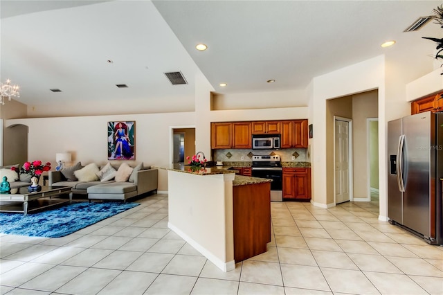 kitchen with light tile patterned floors, stainless steel appliances, tasteful backsplash, and dark stone counters