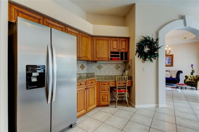 kitchen with stainless steel fridge with ice dispenser, backsplash, light tile patterned floors, and light stone counters