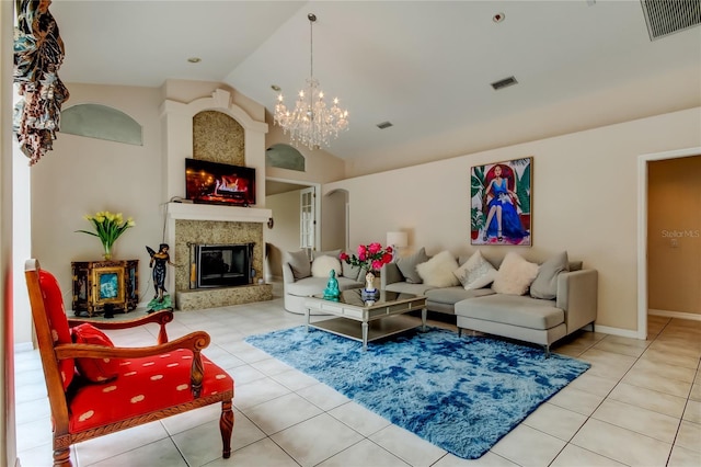 living room with a fireplace, light tile patterned floors, a chandelier, and lofted ceiling