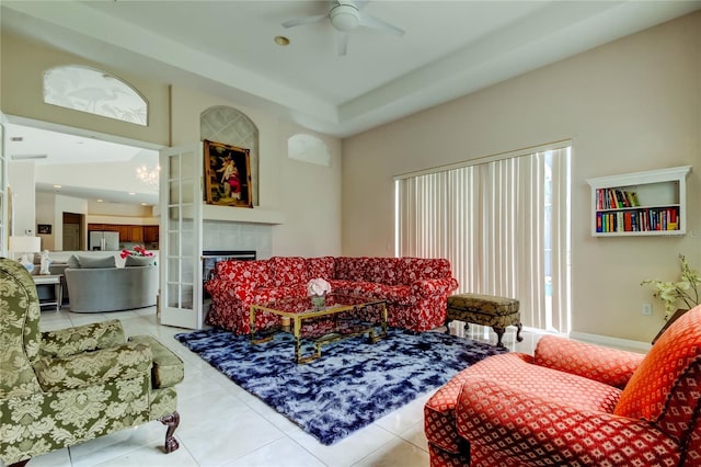 tiled living room featuring ceiling fan and a fireplace