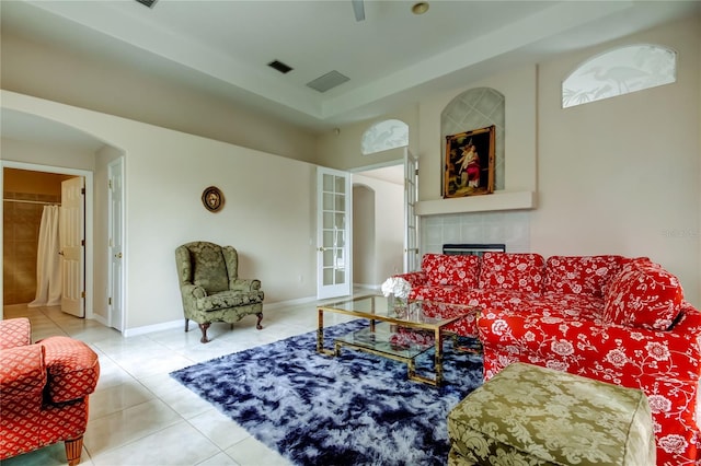 tiled living room featuring a tile fireplace and french doors