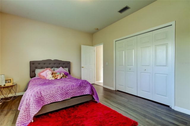 bedroom with dark hardwood / wood-style floors and a closet