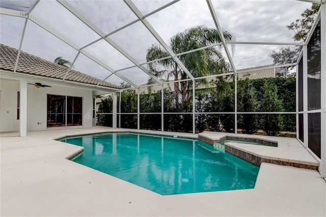 view of pool with an in ground hot tub, glass enclosure, ceiling fan, and a patio area