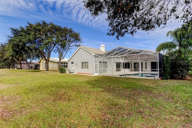 rear view of house featuring a lanai and a yard