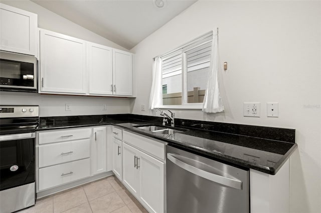 kitchen with vaulted ceiling, appliances with stainless steel finishes, white cabinets, and sink