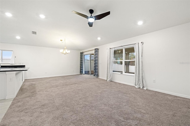 unfurnished living room featuring ceiling fan with notable chandelier and light carpet