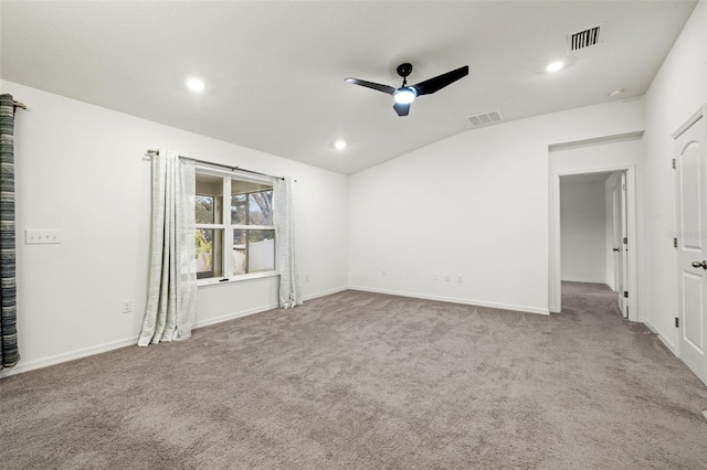 spare room featuring ceiling fan, light colored carpet, and vaulted ceiling