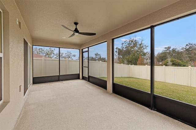 unfurnished sunroom featuring ceiling fan and plenty of natural light