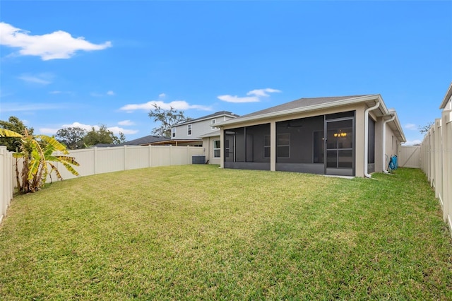 rear view of property with a sunroom and a yard