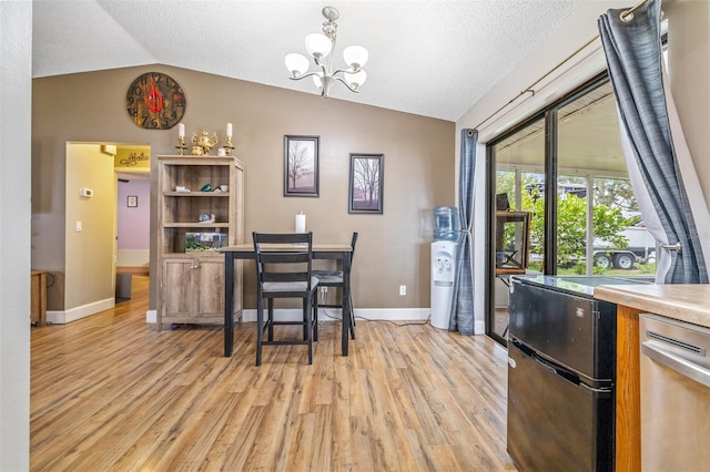 dining area featuring light hardwood / wood-style floors, lofted ceiling, and a notable chandelier