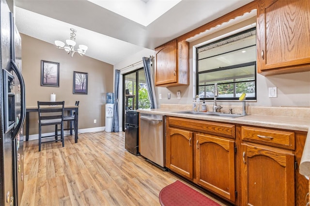 kitchen with light wood-type flooring, stainless steel dishwasher, a chandelier, fridge, and lofted ceiling