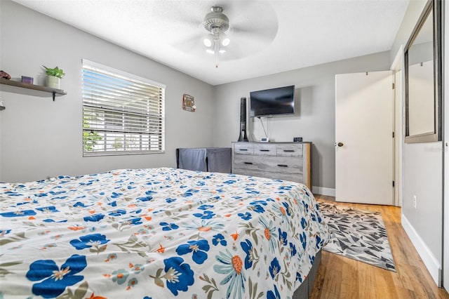 bedroom featuring ceiling fan, light hardwood / wood-style flooring, and a textured ceiling