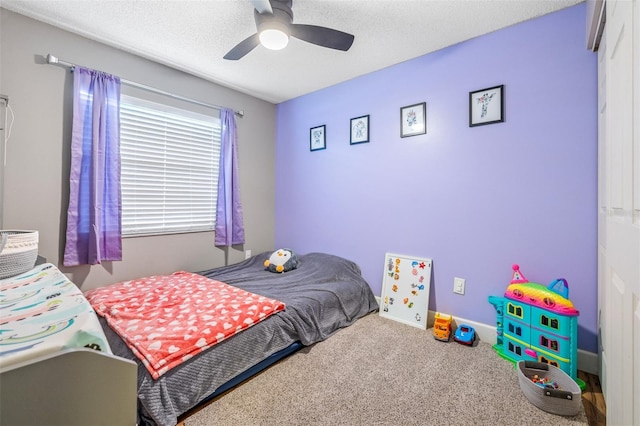 carpeted bedroom with ceiling fan and a textured ceiling