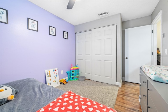 bedroom featuring ceiling fan, a closet, and light wood-type flooring