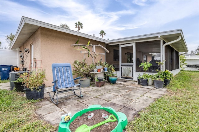 rear view of house featuring a sunroom and a patio