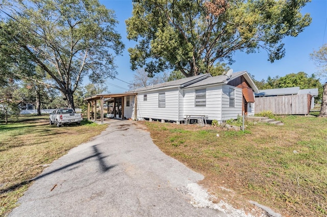 manufactured / mobile home with a carport and a front lawn