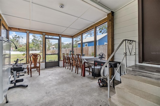 sunroom featuring a drop ceiling and a healthy amount of sunlight