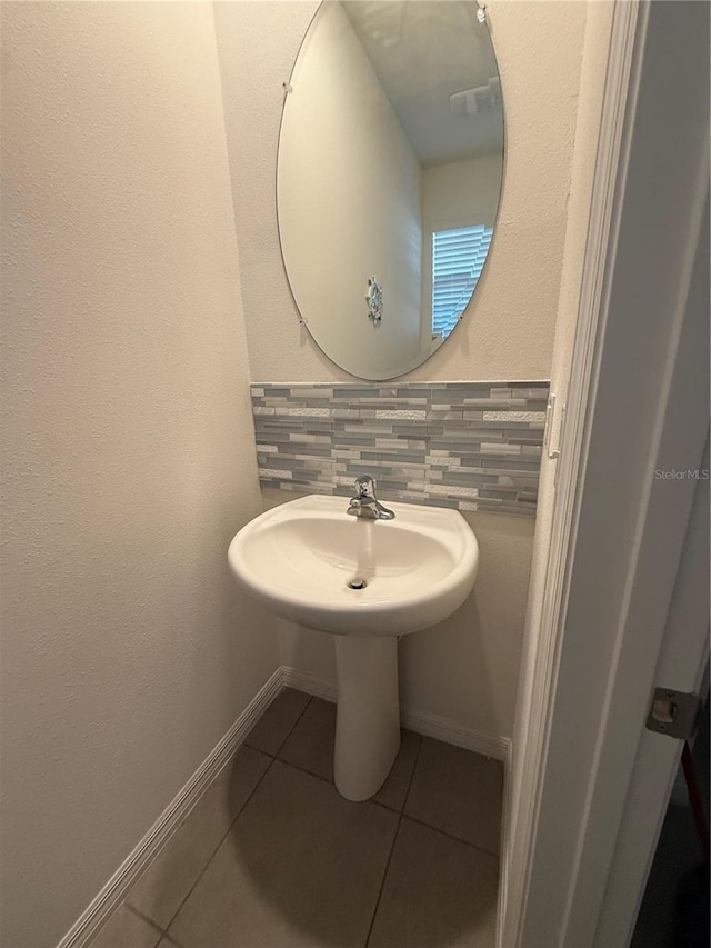 bathroom featuring tile patterned flooring and backsplash