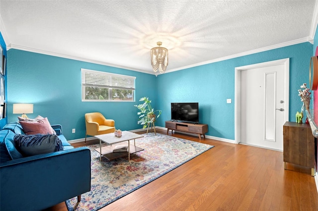 living room featuring wood-type flooring, a chandelier, a textured ceiling, and ornamental molding