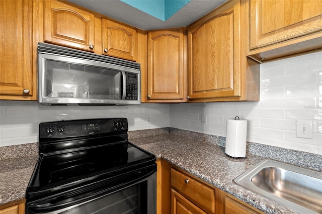 kitchen with sink, dark stone counters, electric range, and decorative backsplash