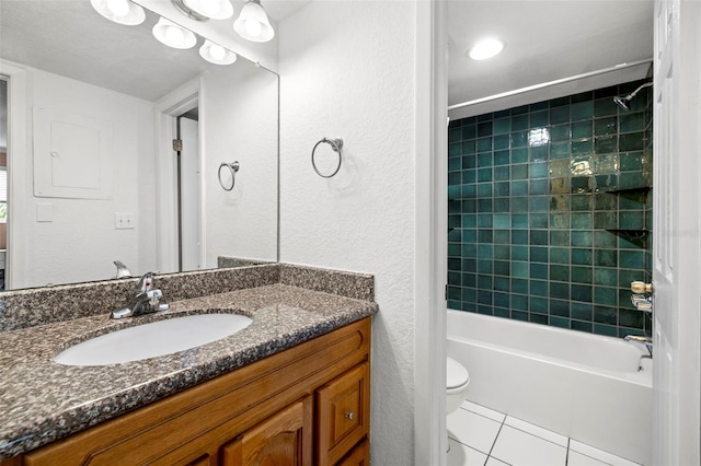 full bathroom with toilet, tiled shower / bath, tile patterned floors, and vanity