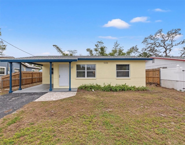 view of front of property with a carport and a front lawn