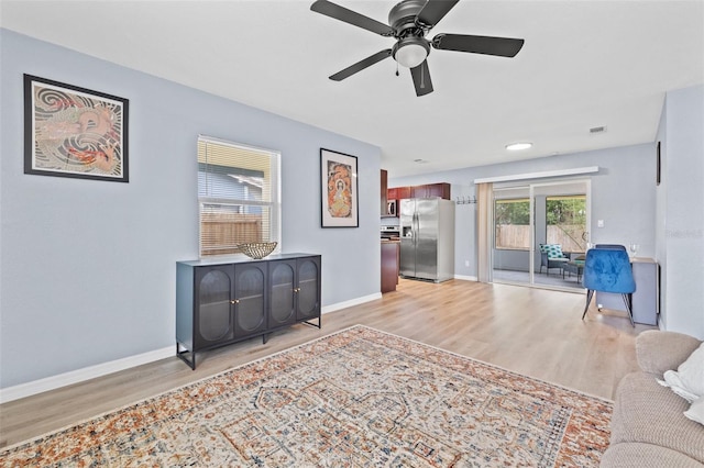 living room featuring ceiling fan and light hardwood / wood-style floors