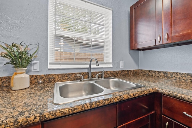 kitchen featuring sink, plenty of natural light, and dark stone counters