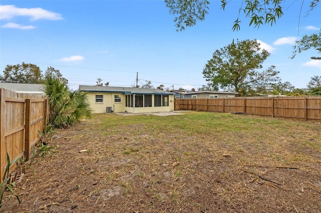 rear view of house with a yard and a sunroom