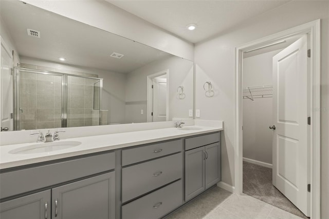 bathroom with tile patterned floors, vanity, and a shower with shower door