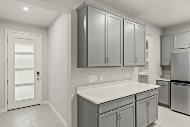 kitchen featuring stainless steel fridge and gray cabinetry