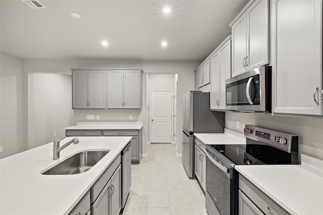 kitchen featuring light tile patterned flooring, stainless steel appliances, and sink