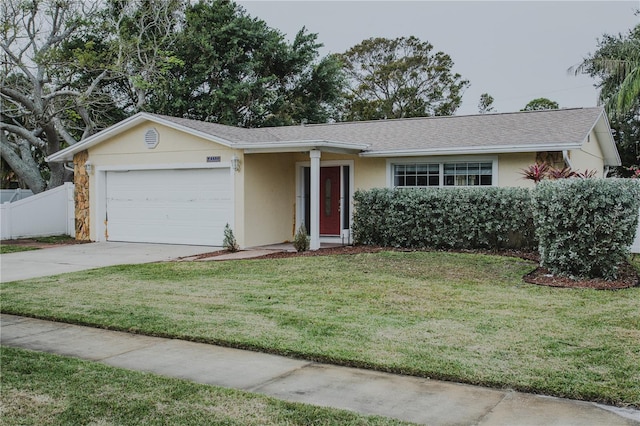 single story home with a garage and a front lawn