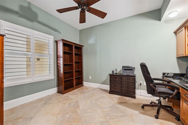 office space featuring ceiling fan and baseboards