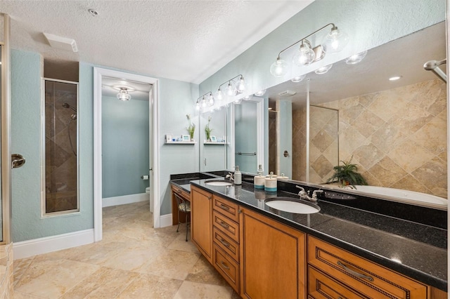 full bathroom with a textured ceiling, a stall shower, a sink, and toilet