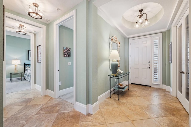 foyer with a chandelier and baseboards