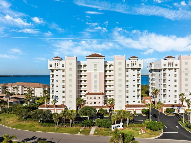 view of building exterior with a water view and uncovered parking