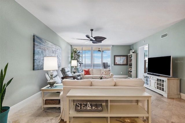 living area with baseboards, visible vents, and ceiling fan