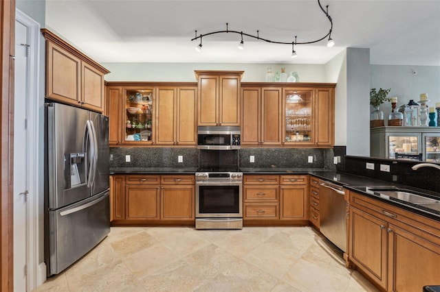 kitchen with brown cabinets, a sink, stainless steel appliances, and backsplash