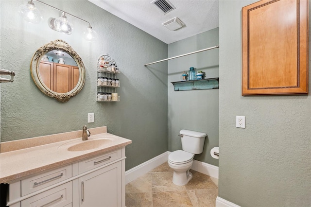 bathroom featuring baseboards, visible vents, a textured wall, and toilet