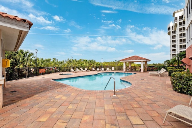 community pool featuring a gazebo, a patio area, and a hot tub